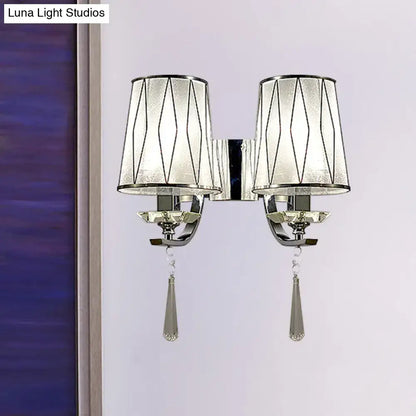Modern chrome wall lighting fixture with frosted glass shades, geometric black lines, and crystal teardrop pendants
