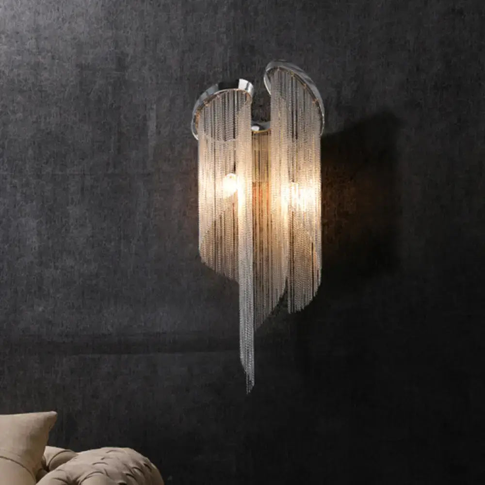 Modern chrome crystal wall sconce with curved frame and clear cascading beads for bedroom bedside lighting