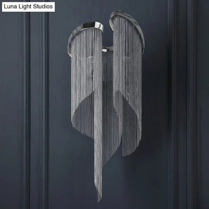 Modern chrome crystal wall sconce with silver chain chandelier featuring wing-like design and metallic finish for bedroom use