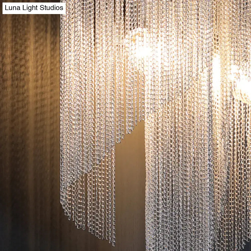 Modern chrome crystal wall sconce with a shimmering silver chain curtain of cascading interlocking links for bedside lighting