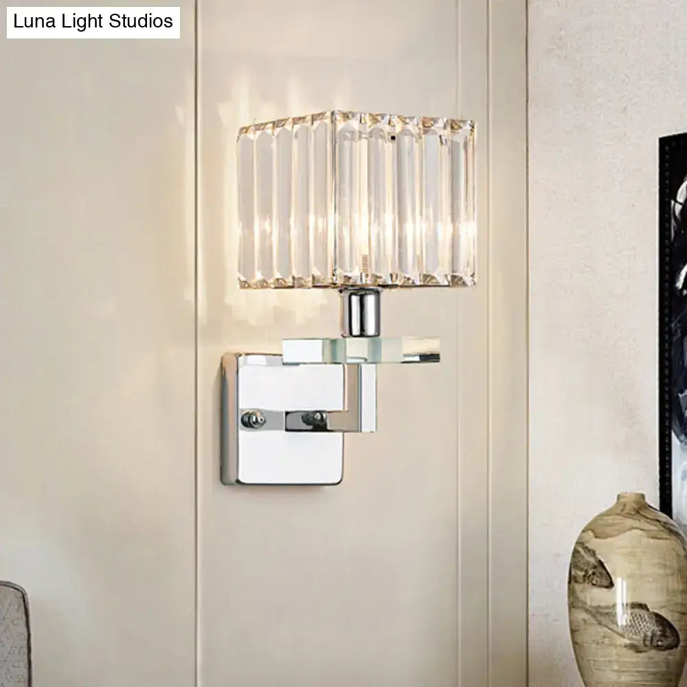 Modern chrome cuboid wall mounted light with a clear faceted crystal shade and polished chrome metal base for bedroom use