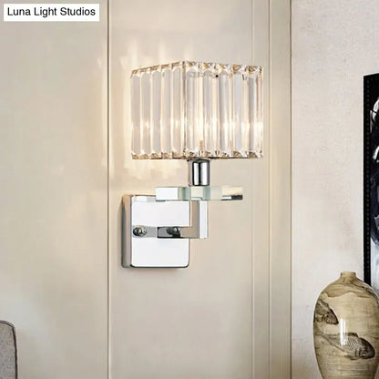 Modern chrome cuboid wall mounted light with a clear faceted crystal shade and polished chrome metal base for bedroom use