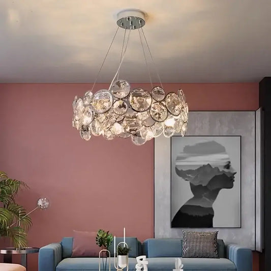 A modern chrome decorbites crystal led chandelier with clear faceted glass discs for dining room lighting