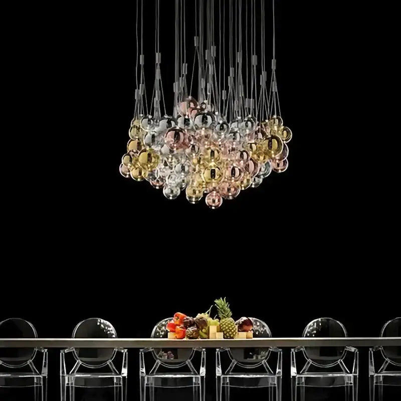 A modern chrome decorbites glass ball pendant light fixture with iridescent gold, rose gold, and clear glass spheres