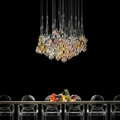 A modern chrome decorbites glass ball pendant light fixture with iridescent gold, rose gold, and clear glass spheres