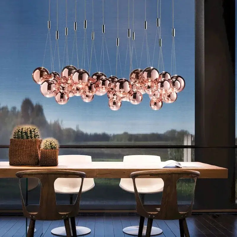 Modern rose gold pendant light fixture with decorbites glass ball cluster suspended by thin cables for living room