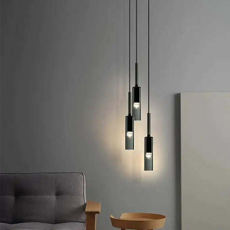 Modern black cylindrical decorbites glass chandeliers with chrome finishes hang from cords for living room ambient lighting