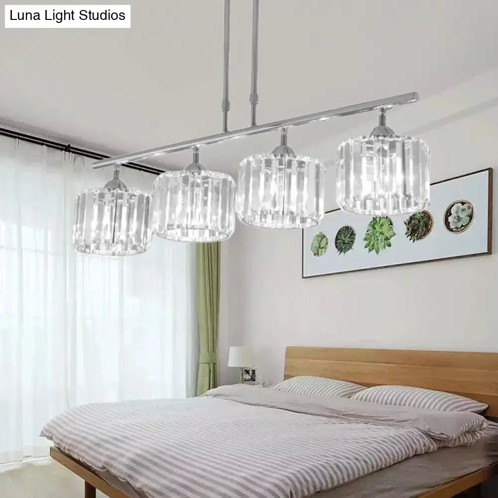 Modern chrome drum pendant light with four cylindrical crystal shades suspended from a sleek chrome bar for bedroom use
