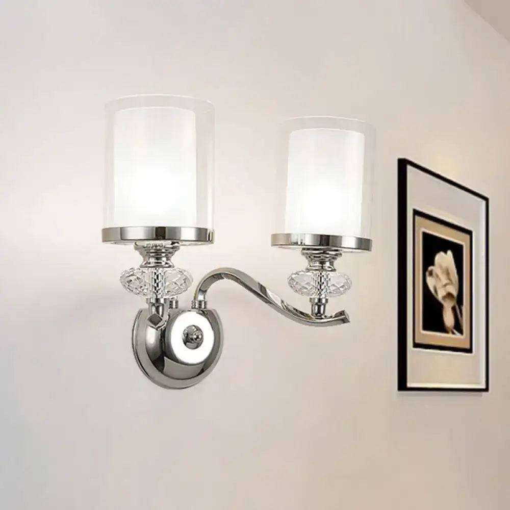Modern chrome dual cylinder bathroom sconce with curvy arm, frosted glass shades, and crystal accents fixture height visible