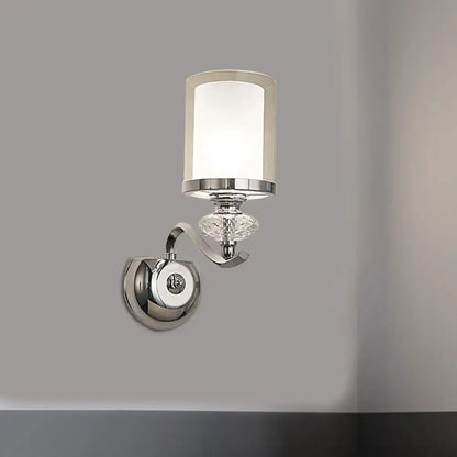 Modern chrome dual cylinder bathroom sconce with curvy arm featuring frosted glass shade and faceted crystal accent
