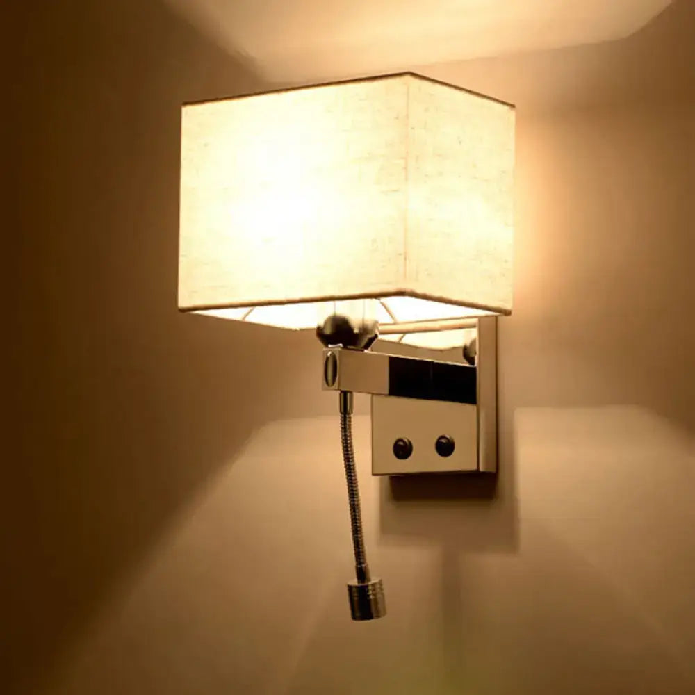 A modern chrome fabric led wall sconce with an off-white linen shade and sleek metal arm for bedroom lighting