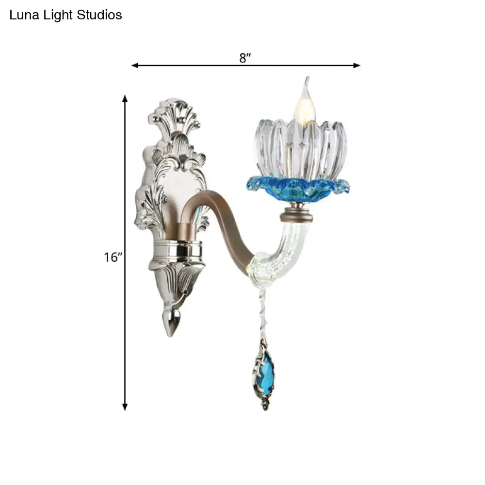 Elegant chrome finish wall light featuring clear glass, silver and blue ornate metalwork for bedroom sconce use