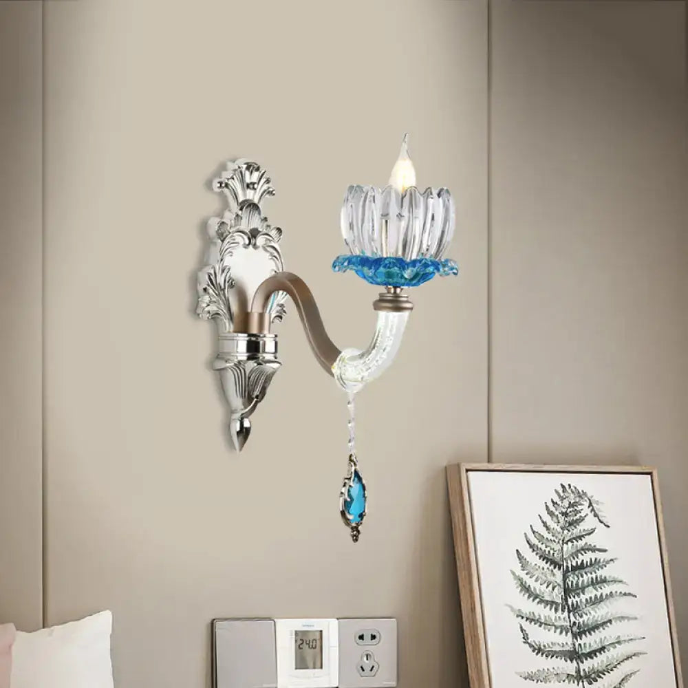 Elegant modern chrome finish wall light with clear glass candle holder and blue crystal accents for bedroom use