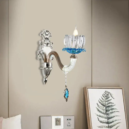 Elegant modern chrome finish wall light with clear glass candle holder and blue crystal accents for bedroom use