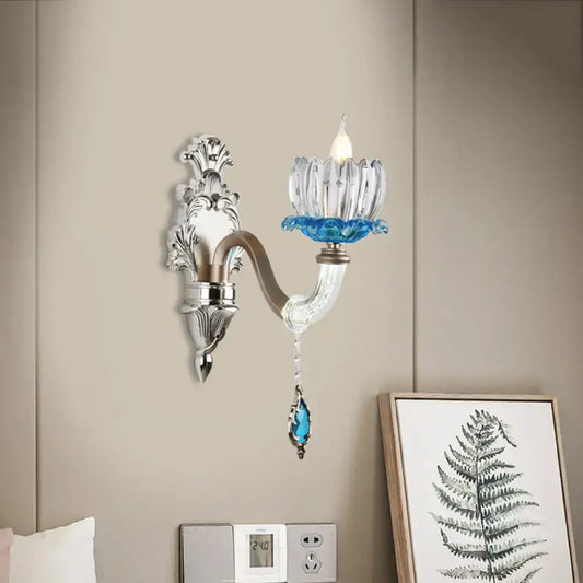 Elegant modern chrome finish wall light with clear glass candle holder and blue crystal accents for bedroom use