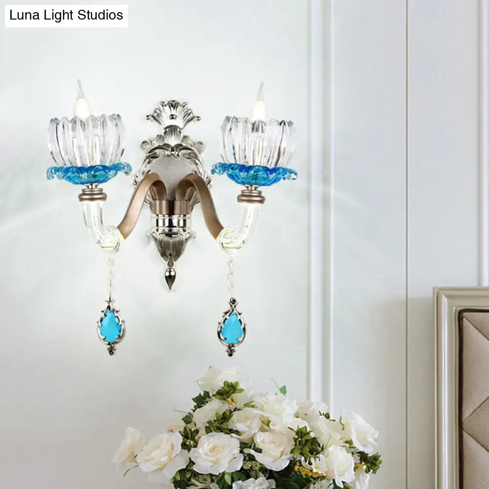 Elegant modern wall light with chrome finish clear glass shades and vibrant blue crystal accents for bedroom use