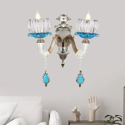Elegant modern chrome finish wall light with clear glass petals and blue crystal accents for bedroom sconce lighting