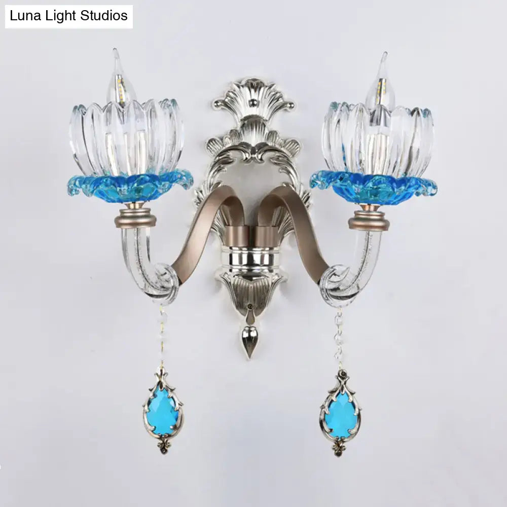 Modern chrome finish clear glass wall light with silver and blue glass and ornate metal arms for bedroom sconce