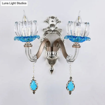Modern chrome finish clear glass wall light with silver and blue glass and ornate metal arms for bedroom sconce