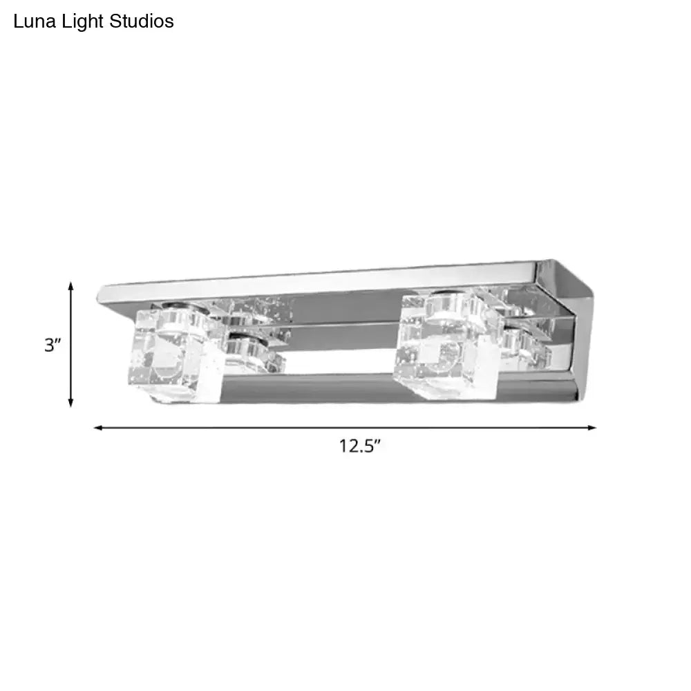 Modern chrome finish rectangular wall sconce with two clear crystal cube accents and warm white light for bathroom vanity