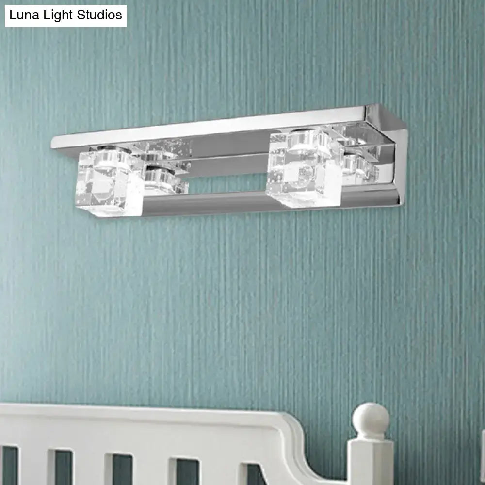 Modern chrome finish crystal cube vanity sconce with two clear crystal accents emitting warm white light for bathroom use