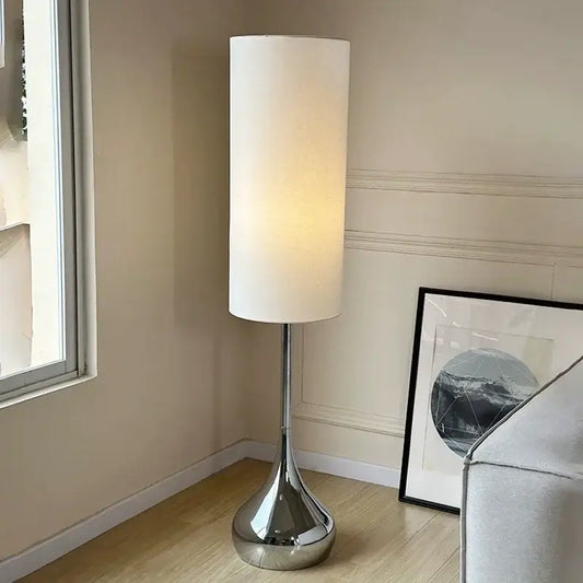 Modern chrome floor lamp with a tall cylindrical cream fabric shade for stylish living room decorbites cream fabric