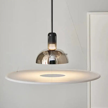 Modern chrome flying saucer chandelier with sleek chrome dome and white diffuser, suspended by black cord for living room lighting
