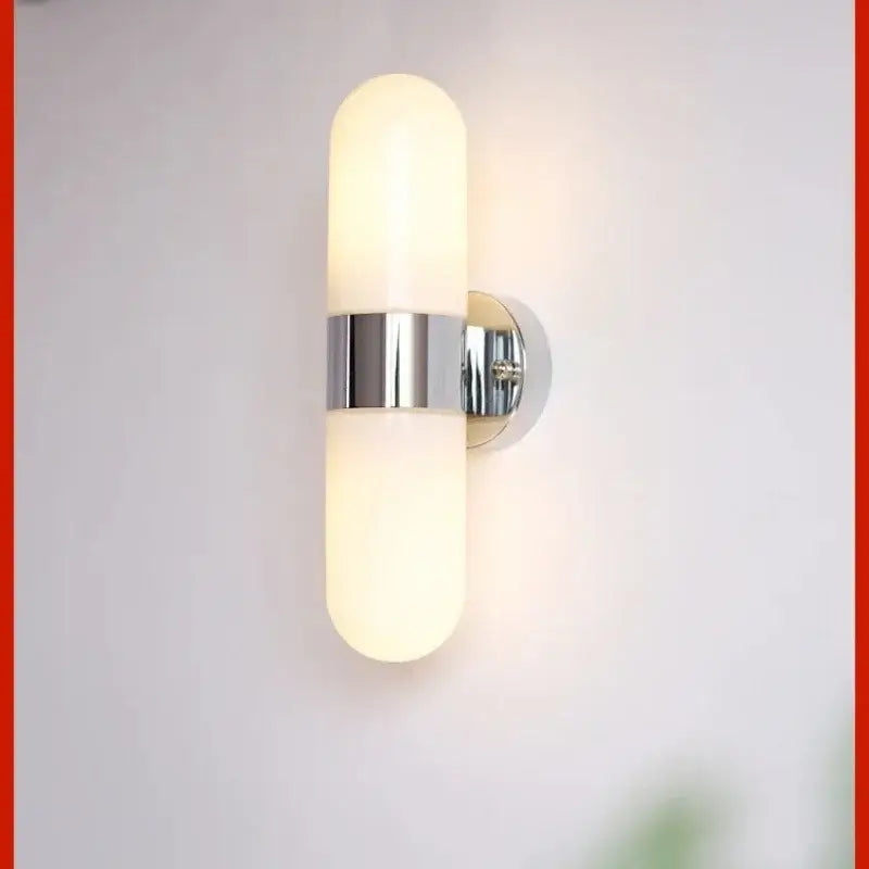 Modern chrome frosted glass vanity mirror light with two cylinders and central metallic band for bathroom use
