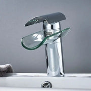 Modern chrome glass spout basin faucet with transparent glass waterfall spout and handle accents for bathroom use