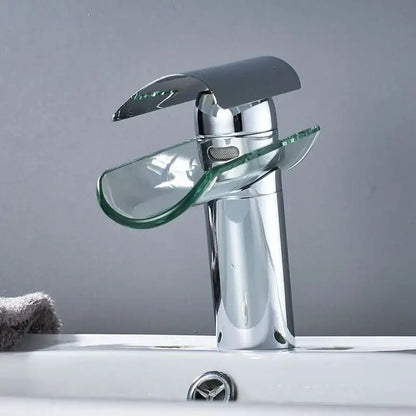 Modern chrome glass spout basin faucet with transparent glass waterfall spout and handle accents for bathroom use