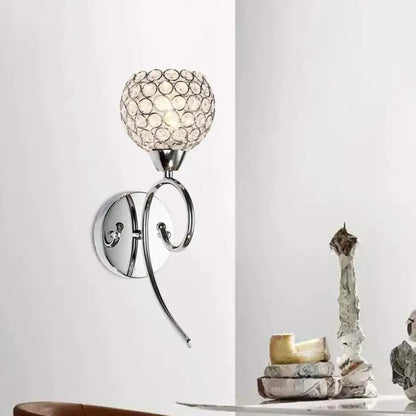 Modern chrome hemisphere crystal wall lamp featuring a spherical crystal globe shade for bedroom lighting