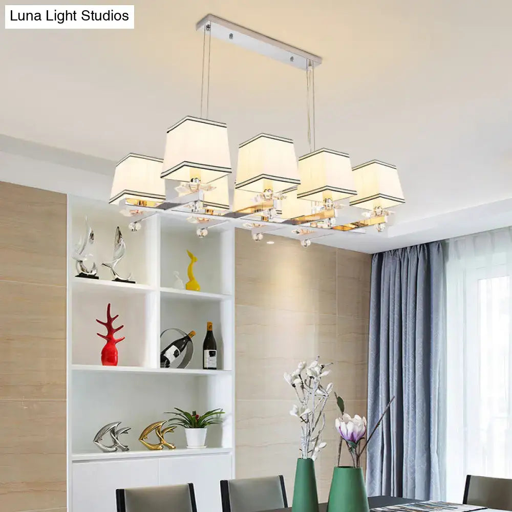 Modern chrome island pendant light with five cream fabric shades and clear crystal accents for dining rooms
