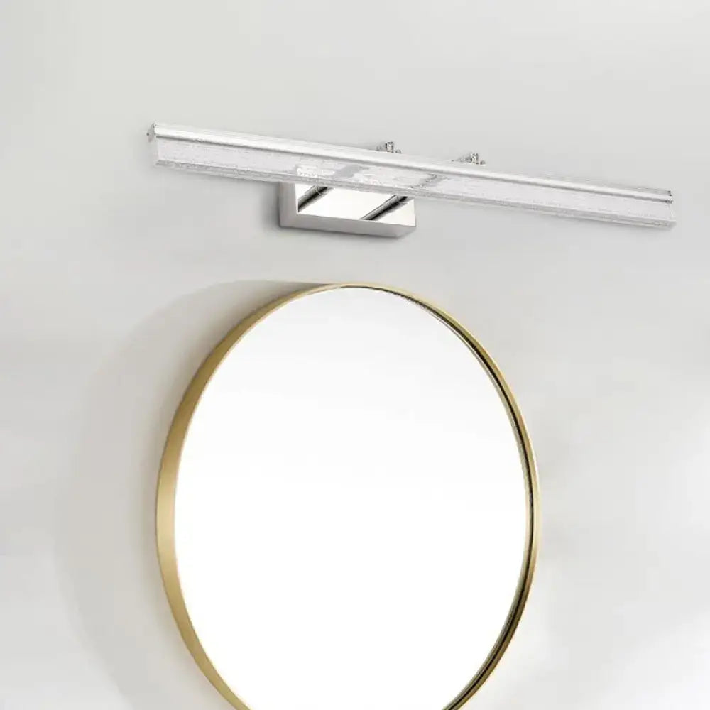 Modern chrome LED vanity light with a sleek rectangular design mounted above a gold mirror for linear shower room bath use