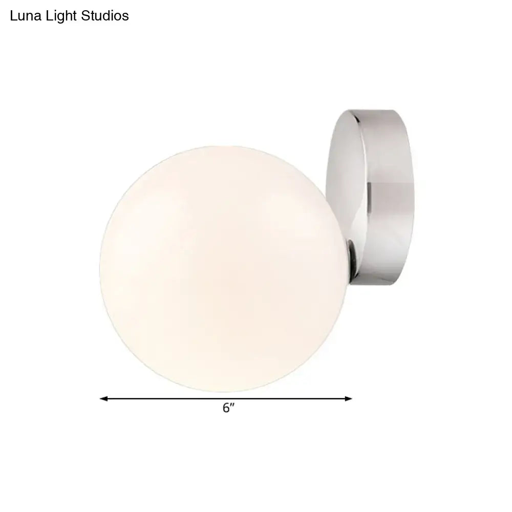Modern chrome milk glass globe wall lamp with frosted glass globe designed as a wall mounted lamp for living rooms