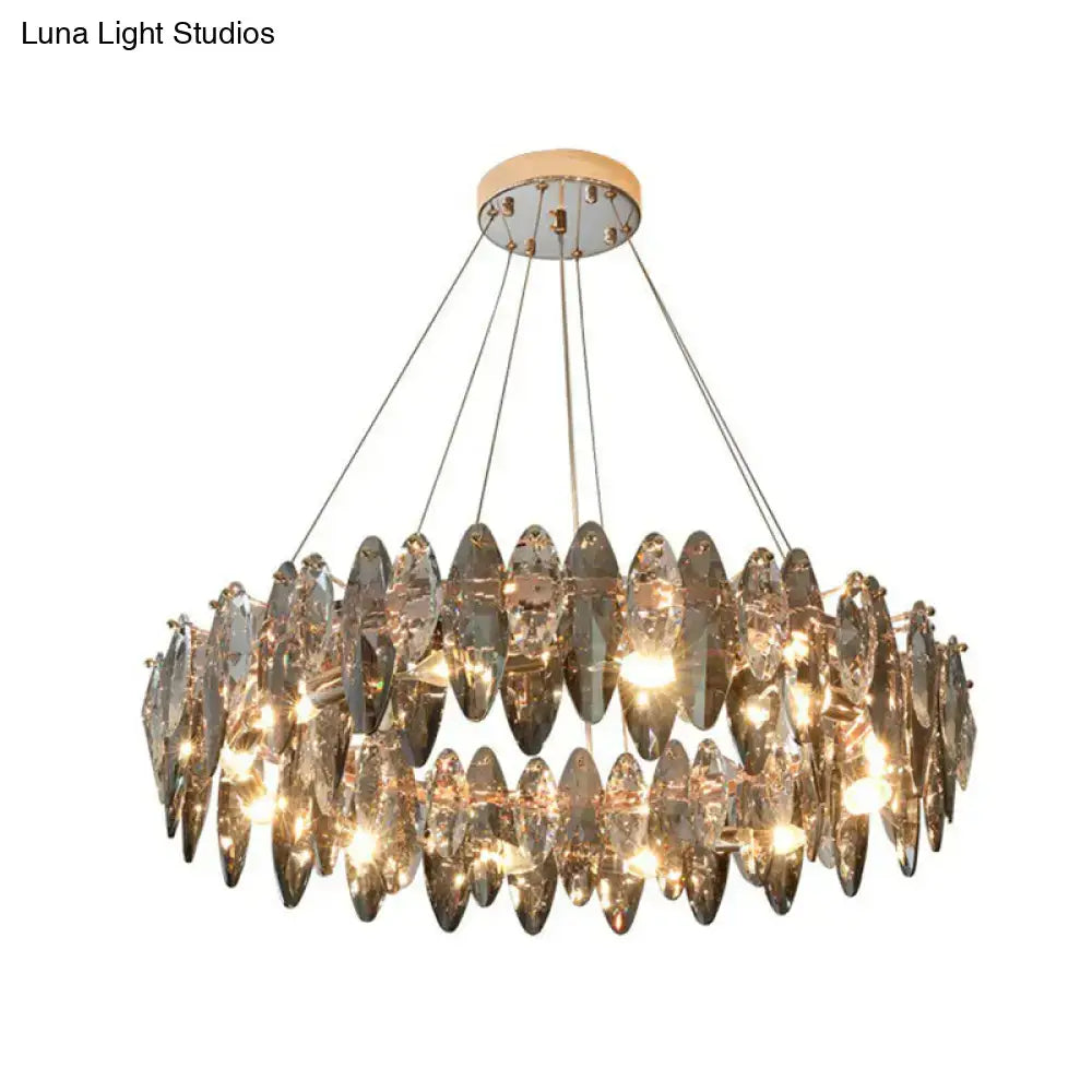 A modern minimalist oval crystal clear pendant chandelier with cascading teardrop crystals and chrome finish for restaurants