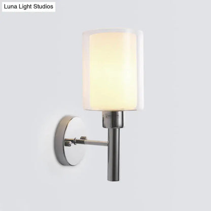 Modern chrome pencil arm sconce light fixture with a cylindrical frosted glass shade and polished chrome wall mount