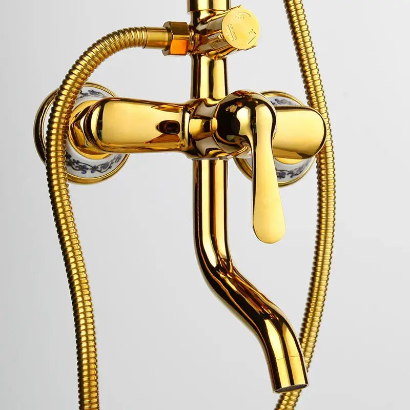 Gold-finished brass shower faucet set with ornate handles and decorative ceramic plates for modern bathroom use