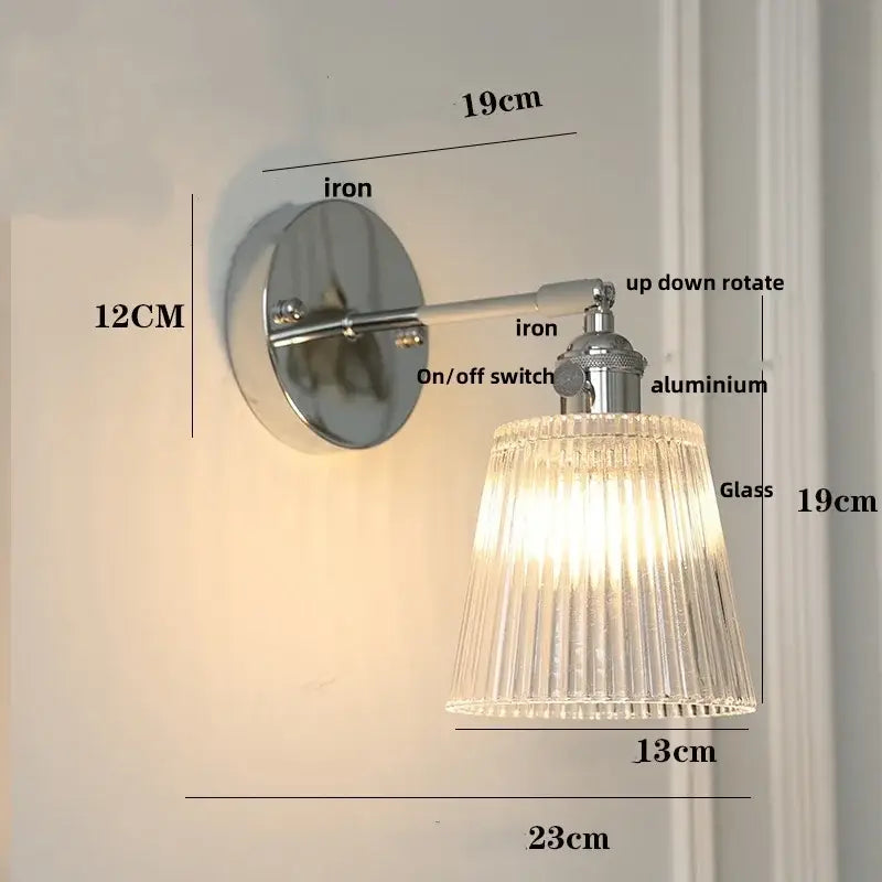 A sleek modern chrome wall lamp with a polished iron base and clear ribbed glass shade by decorbites clear glass