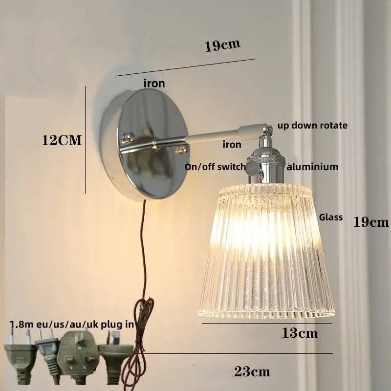 A sleek modern chrome wall lamp with a ribbed clear glass shade and polished iron base for decorbites clear glass lighting