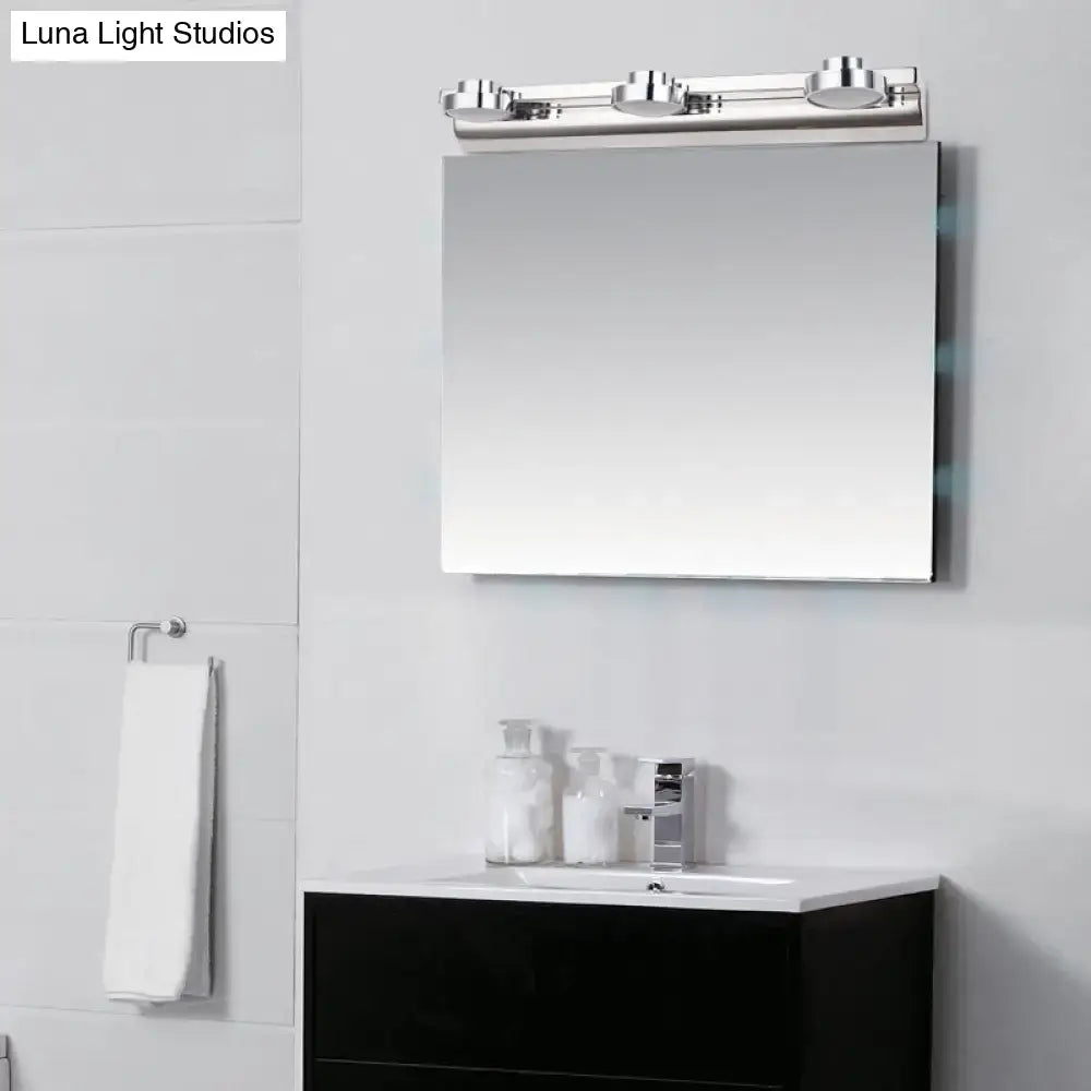 Modern chrome rectangular bathroom mirror with integrated three-light vanity fixture featuring round wall lamps and acrylic shades