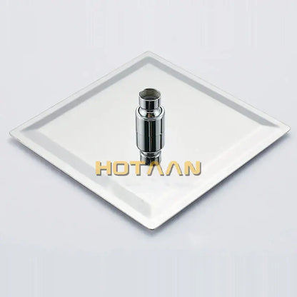Modern chrome square rain shower head with cylindrical chrome finish and threaded top resting on white plate