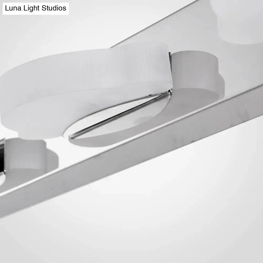 Modern chrome three light vanity mirror light with sleek curved design and frosted glass diffuser in warm color temperature