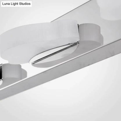 Modern chrome three light vanity mirror light with sleek curved design and frosted glass diffuser in warm color temperature