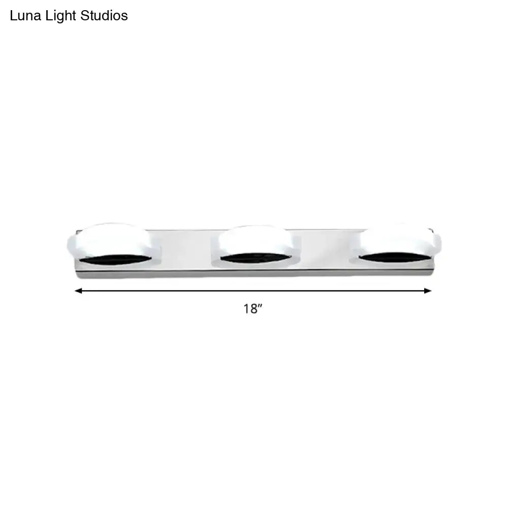Silver chrome three-light vanity mirror light with frosted white globe shades and warm color temperature for bathroom