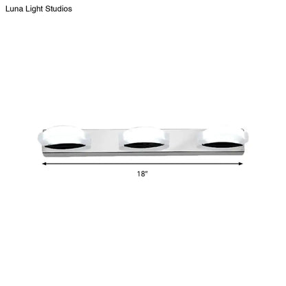 Silver chrome three-light vanity mirror light with frosted white globe shades and warm color temperature for bathroom