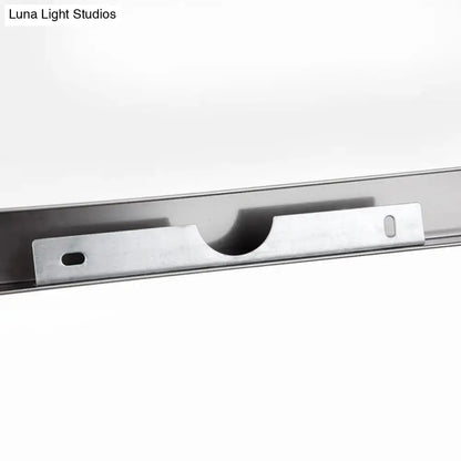 Silver metallic mounting bracket with central cutout for secure attachment on modern chrome vanity mirror light with warm color temperature