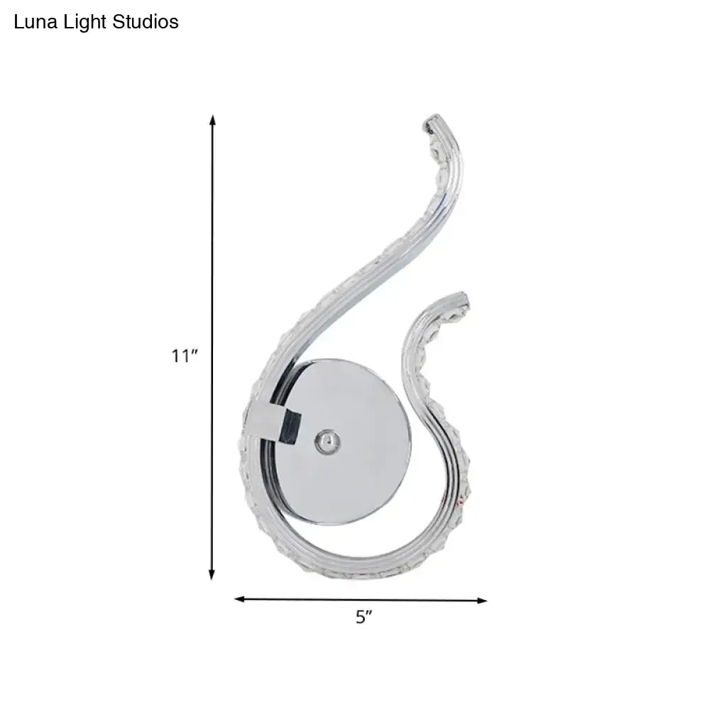 Modern chrome twist led wall light with ornate s-shaped design and embedded crystals emitting warm white light