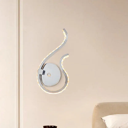 Modern chrome twist wall light with sleek curved design and integrated warm white light for bedroom illumination