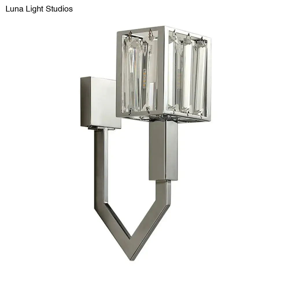 Modern chrome wall lamp with clear crystal encased rectangular light and geometric metal frames for living room use