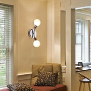 Modern chrome wall lamp with white glass fixture featuring two frosted glass bulbs and a sleek bulb base for bedroom use